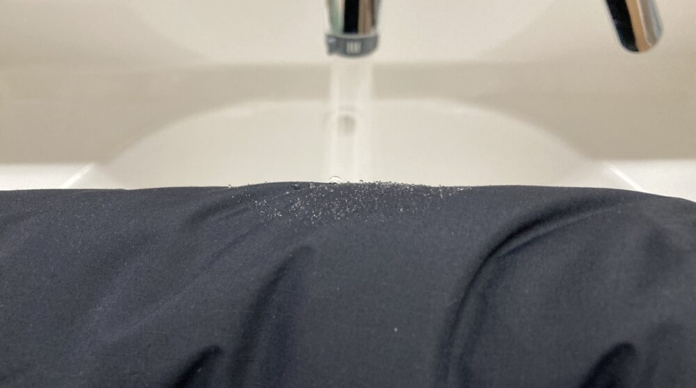 ジップインサニーヌックジャケットが水を弾いているところ