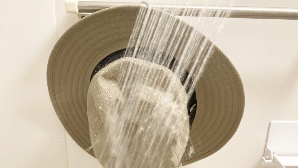 ゴアテックスハットの防水テストでシャワーを当てているところ